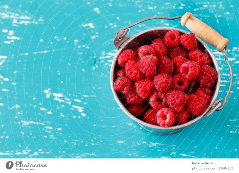 Fresh raspberries in a small metal bucket Fruit Dessert Nutrition Breakfast Vegetarian diet Diet Summer Natural Blue Pink Red Turquoise background Berries