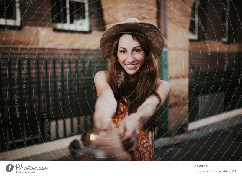 Cute girl with hat pulling from her boyfriend hand while walking in the street. Lifestyle Shopping Joy Leisure and hobbies Vacation & Travel Trip Adventure