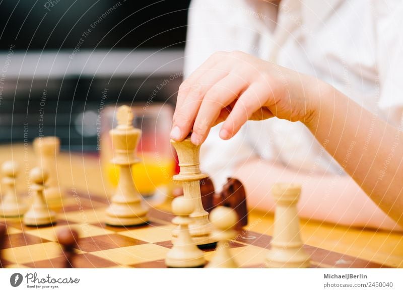 Boy of primary school age plays chess Joy Leisure and hobbies Playing Board game Chess Flat (apartment) Living room Think Boy (child) Colour photo Interior shot