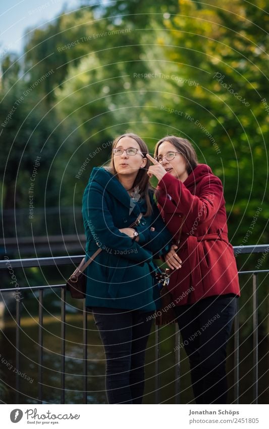 happy twin sisters stand on a bridge and look up Lifestyle Style Joy luck Human being Feminine Young woman Youth (Young adults) Brothers and sisters Sister 2