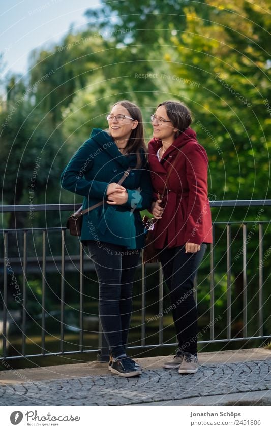 happy twin sisters stand on a bridge and look up Lifestyle Style Joy luck Human being Feminine Young woman Youth (Young adults) Brothers and sisters Sister 2