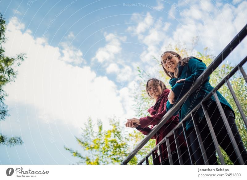 happy twin sisters stand on a bridge and look down Lifestyle Style Joy luck Human being Feminine Young woman Youth (Young adults) Brothers and sisters Sister 2