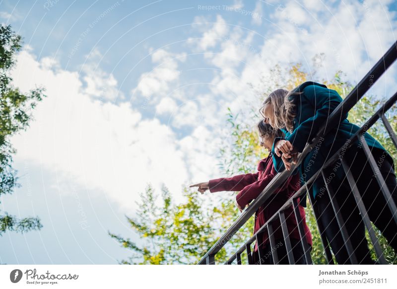 happy twin sisters stand on a bridge and look up Lifestyle Style Joy luck Human being Feminine Young woman Youth (Young adults) Brothers and sisters Sister 2