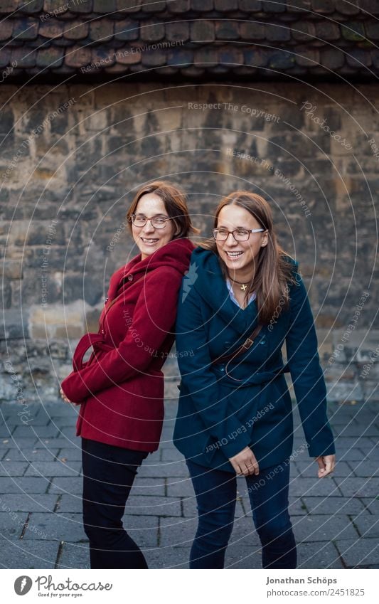 happy twin sisters having fun in front of an old wall Lifestyle Style Joy luck Human being Feminine Young woman Youth (Young adults) Brothers and sisters Sister