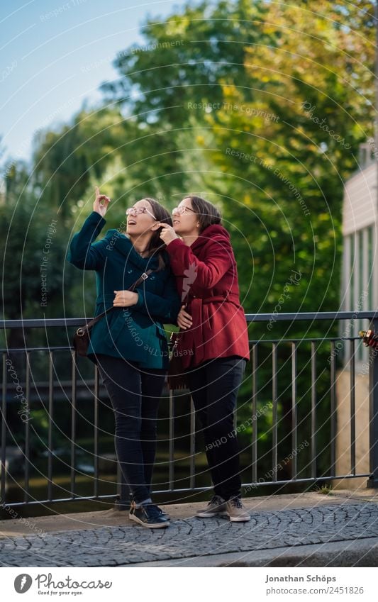 happy twin sisters stand on a bridge and look up Lifestyle Style Joy luck Human being Feminine Young woman Youth (Young adults) Brothers and sisters Sister 2