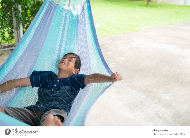 The little boy sitting at the hammock and he so happy Lifestyle Joy Happy Relaxation Leisure and hobbies Vacation & Travel Summer Garden Child Human being