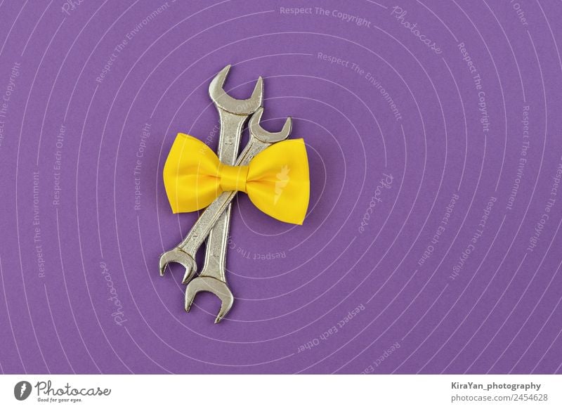 Two crossed wrenches with yellow tie bow on violet background Shopping Leisure and hobbies Decoration Feasts & Celebrations Birthday Tool Masculine Father