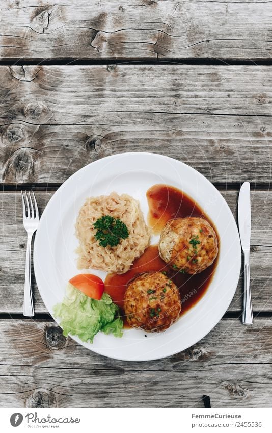 Bacon dumplings with sauerkraut and sauce Nutrition Lunch Buffet Brunch Organic produce To enjoy Dumpling Salad leaf Sauce Cutlery Plate Wooden table