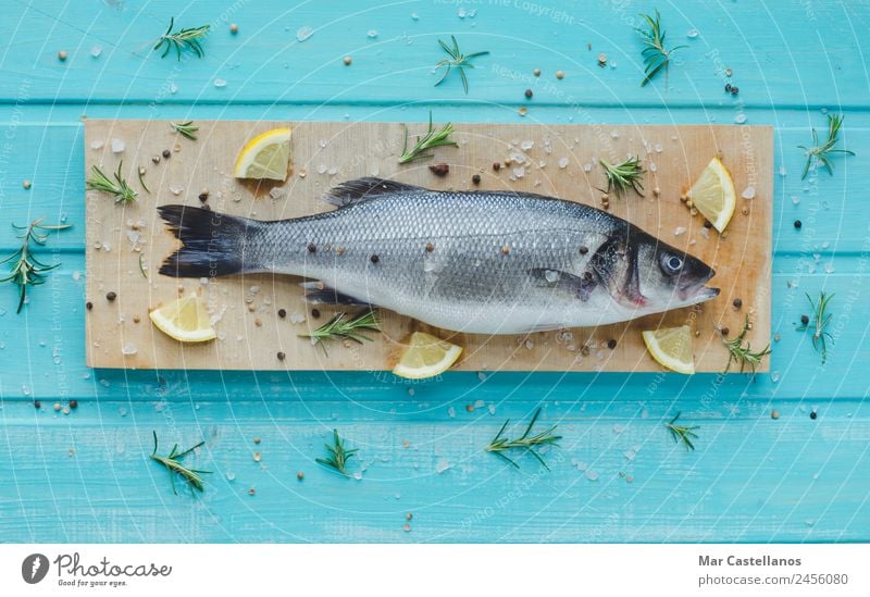 Sea bass with spices on kitchen table and blue wooden background Seafood Herbs and spices Eating Dinner Diet Table Restaurant Animal Wood Write Fresh Delicious