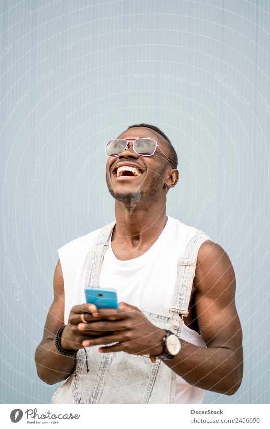 African man blue background with mobile phone. Lifestyle Style Happy To talk Telephone Technology Human being Man Adults Fashion Afro Old To enjoy Listening