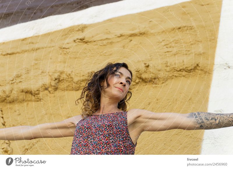 Tattooed woman in front of a painted wall Lifestyle Style Happy Beautiful Face Relaxation Calm Human being Woman Adults Art Facade Street Piercing Curl Graffiti