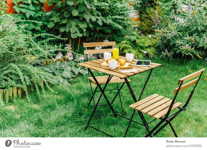 Morning Breakfast In Green Garden With French Croissant, Coffee Cup, Orange Juice, Tablet and Notes Book On Wooden Table Background picture Summer White Food