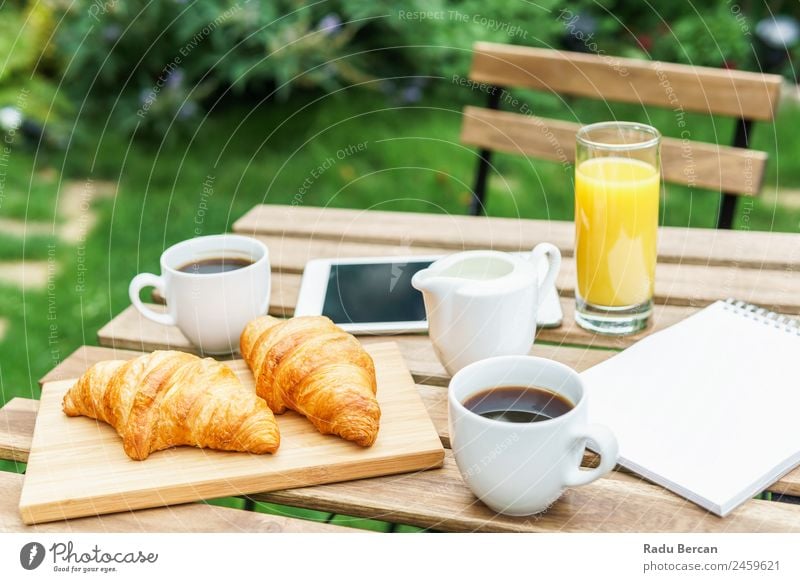 Morning Breakfast In Green Garden With French Croissant, Coffee Cup, Orange Juice, Tablet and Notes Book On Wooden Table Background picture White Food Drinking