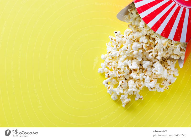 Striped box with popcorn on yellow background. Copyspace Food Nutrition Eating Organic produce Vegetarian diet Fast food Finger food Yellow Red White Popcorn