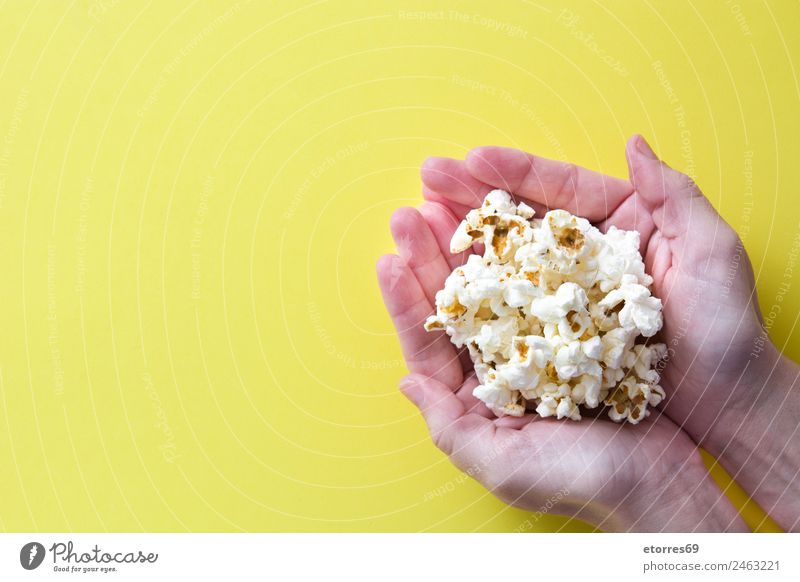 woman with popcorn in hand on yellow background. Copyspace Food Nutrition Eating Organic produce Vegetarian diet Diet Fast food Finger food Catch Yellow White