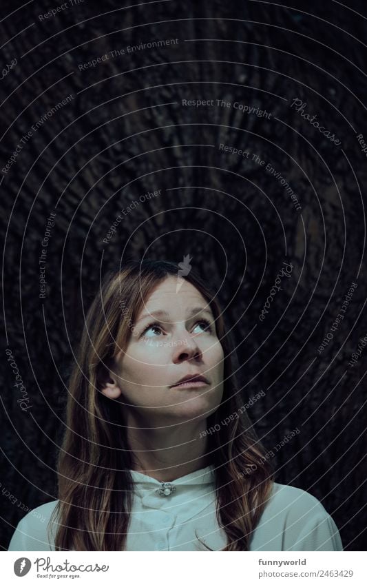 Portrait of anxious woman in front of a tree looking upwards Human being Woman Adults 1 30 - 45 years Hair and hairstyles Brunette Long-haired Part Threat Dark