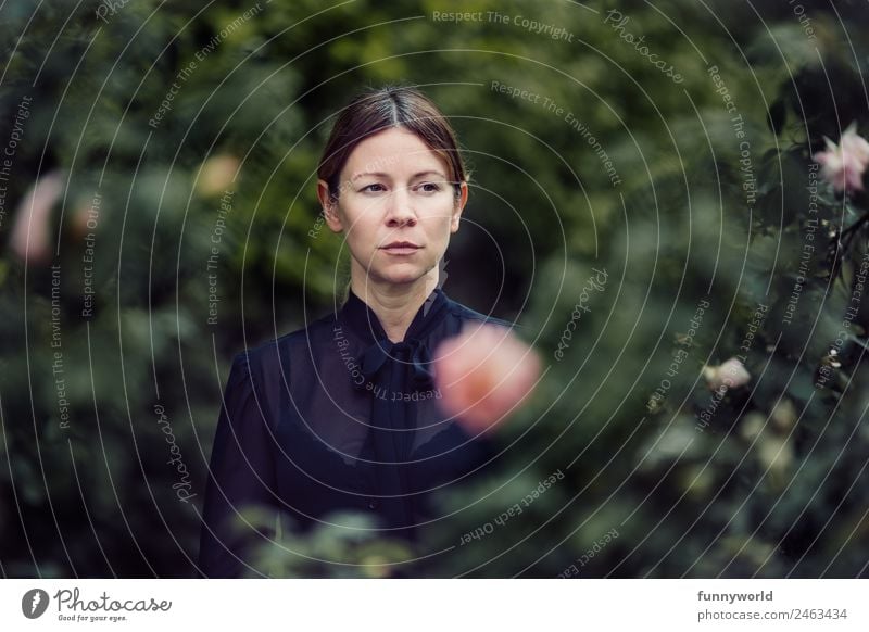 Serious woman standing amid green plants Human being Feminine Woman Adults 1 30 - 45 years Threat Dark Cold Mistrust Envy Loneliness Pride Jealousy Demanding