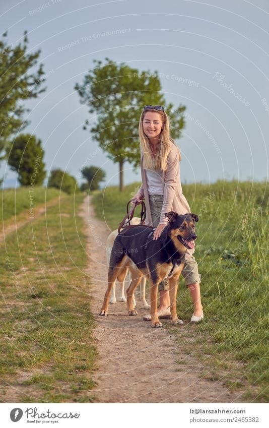 Attractive smiling blond woman with her two dogs Lifestyle Happy Beautiful Summer Woman Adults Friendship Nature Animal Warmth Grass Park Blonde Pet Dog Smiling