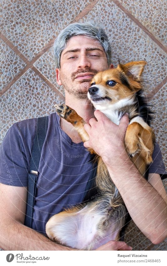 Portrait of a man with his dog lying on the ground. Animal Pet Dog Brick Touch To enjoy Love Together Modern Natural Positive Blue Brown Yellow Black Joy