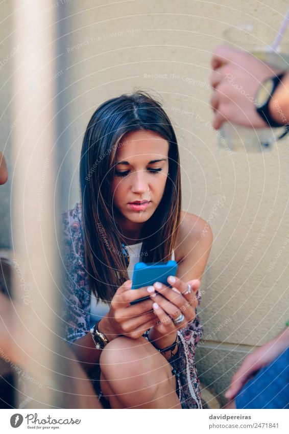 Young woman looking a smartphone outdoors with her friends Lemonade Juice Lifestyle Joy Happy Relaxation Leisure and hobbies Summer To talk Telephone Cellphone