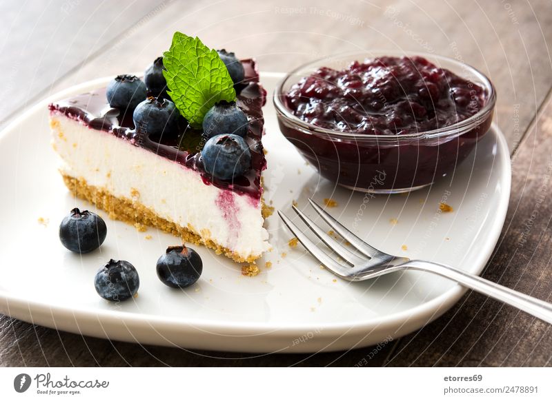 Piece of blueberry cheesecake on wooden table Cheese Cheese slice Blueberry Baked goods Cake Dessert Fruit Sweet Candy Food Healthy Eating Food photograph