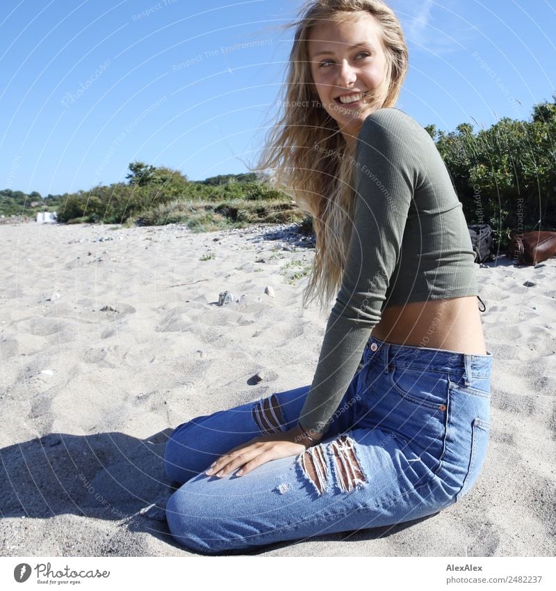 Young woman sits at the Baltic Sea beach Lifestyle pretty Well-being Trip Summer Summer vacation Sun Sunbathing Beach Ocean Youth (Young adults) 18 - 30 years