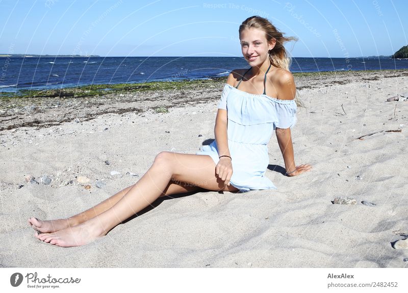 Young, long-legged woman sitting on the Baltic Sea beach Lifestyle Joy Happy pretty Well-being Relaxation Summer Summer vacation Sun Sunbathing Beach Ocean