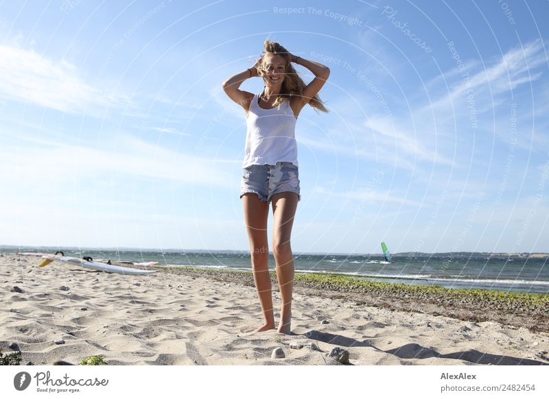 Young, slim woman on the beach of the Baltic Sea in summer wind Lifestyle pretty Relaxation Summer Summer vacation Sun Sunbathing Beach Ocean Waves Young woman