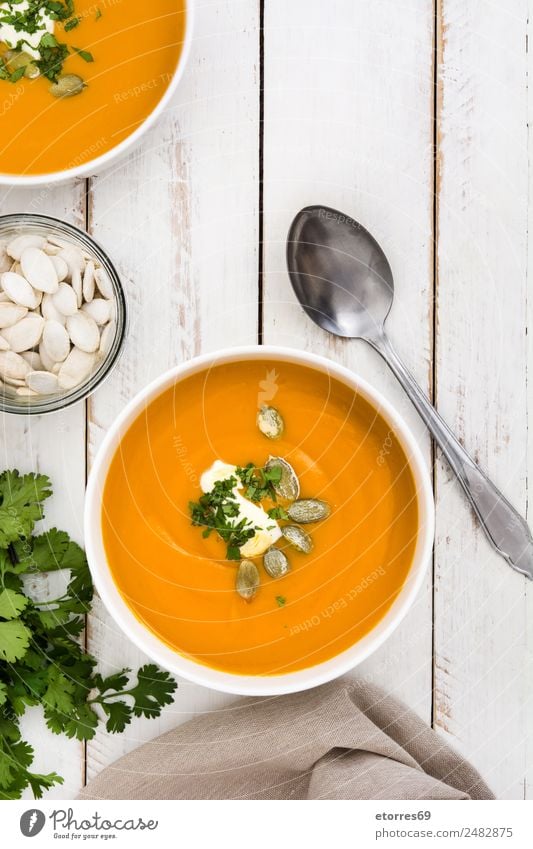 Pumpkin soup Vegetable Soup Stew Bowl Thanksgiving Christmas & Advent Healthy Good Orange Food Seeds Vegetarian diet Vegan diet Wooden table Spoon Tasty Parsley