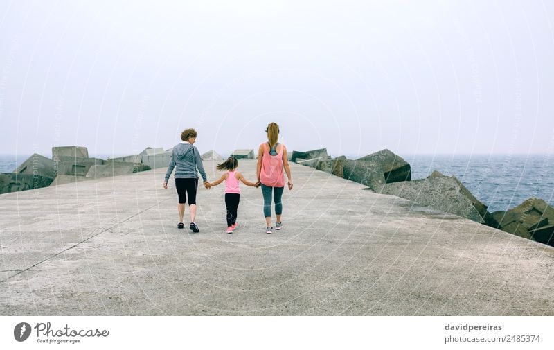 Back view of women walking by sea pier Lifestyle Leisure and hobbies Ocean Sports Child Human being Woman Adults Mother Grandfather Grandmother