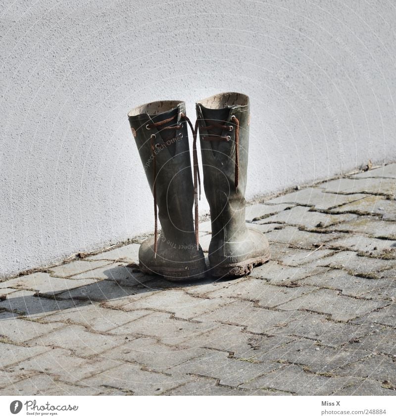 Old Latsch Footwear Boots Rubber boots Dirty Sidewalk Extract Shoelace Second-hand Farm Colour photo Subdued colour Exterior shot Deserted Copy Space left