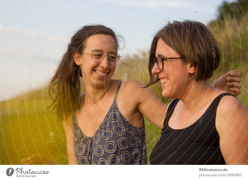 2 young women sit on a meadow and laugh Lifestyle Joy Happy Leisure and hobbies Human being Feminine Young woman Youth (Young adults) Brothers and sisters