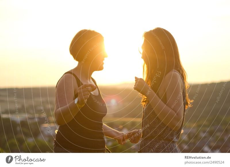 Two young women dancing in the sun Upper body Shallow depth of field blurriness Back-light Sunset Sunrise Sunlight Light Evening Exterior shot Colour photo Love