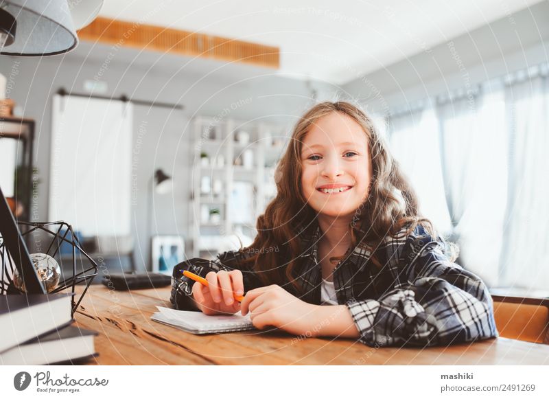 happy school girl doing homework. Smart child working hard Lifestyle Reading Success Child School Study Schoolchild Infancy Book Smiling Write Sit Interest