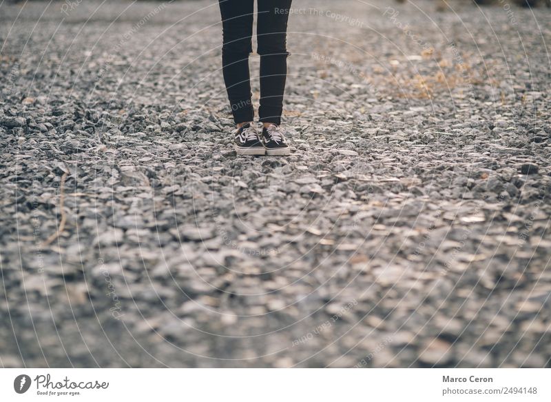 lonely person black dressed standing on a stone floor in the countryside alone background black jeans feet foot landscape legs mountain natural nature outdoors