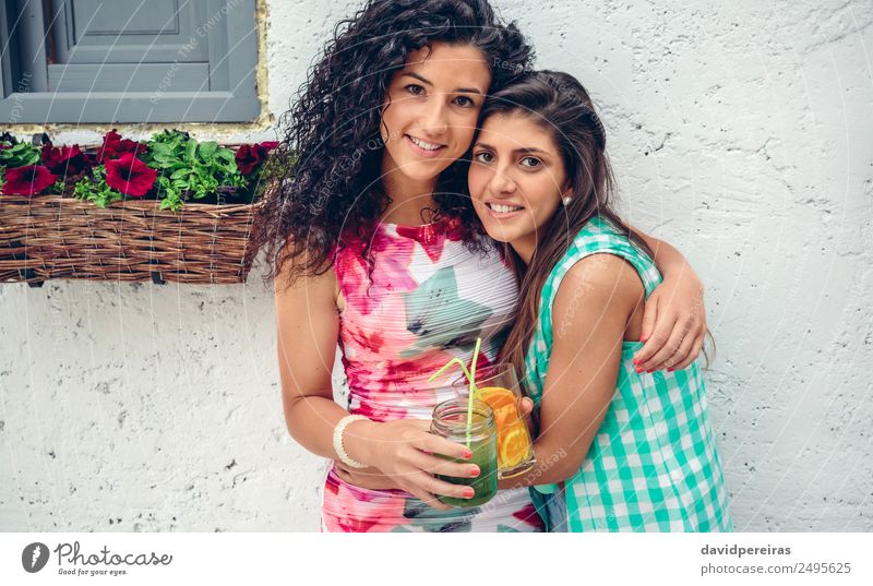 Two women with beverages looking at camera embracing Vegetable Fruit Beverage Juice Lifestyle Joy Happy Leisure and hobbies Summer Human being Woman Adults