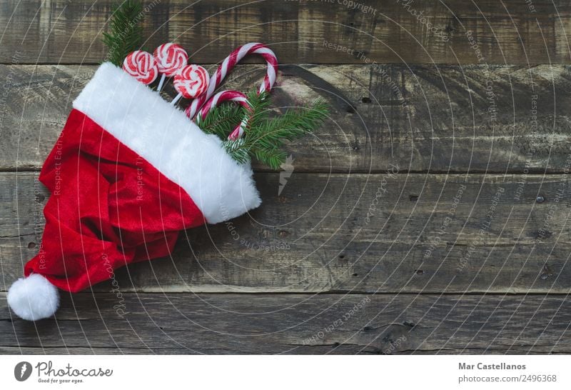 Santa Claus hat with Christmas candy and pine branches Candy Winter Snow House (Residential Structure) Decoration Table Fireside Feasts & Celebrations