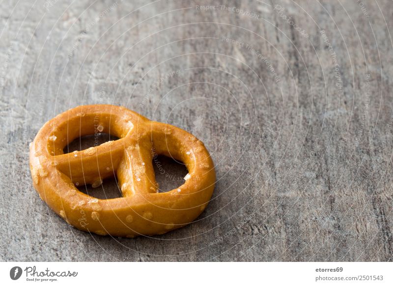 Salted pretzel on wooden background Food Bread Cooking oil Nutrition Eating Breakfast Lunch Vegetarian diet Diet Oktoberfest Wood Brown Pretzel Food photograph