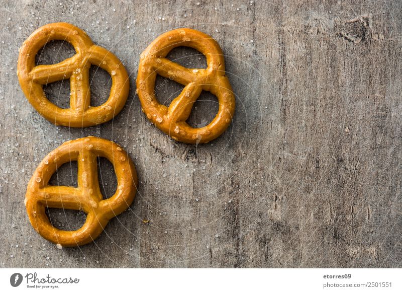 Salted pretzels on wooden background Food Bread Cooking oil Nutrition Vegetarian diet Diet Oktoberfest Wood Good Brown Pretzel Stick Cookie Food photograph