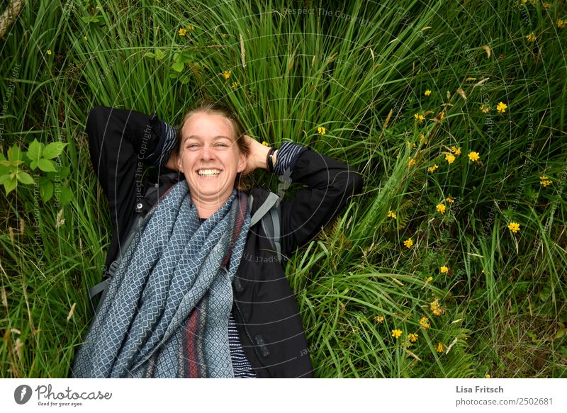 Laughing lying in the grass. Healthy Vacation & Travel Tourism Young woman Youth (Young adults) 1 Human being 18 - 30 years Adults Nature Flower Grass Jacket