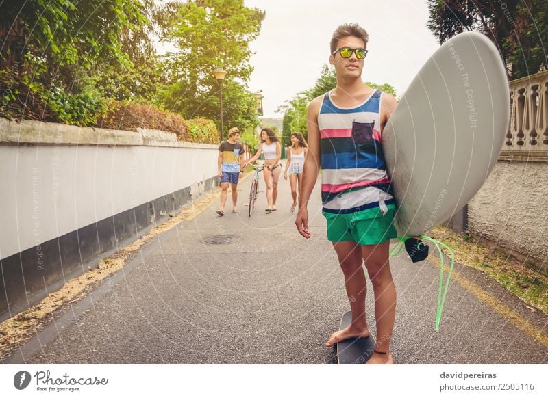 Young man riding on skate and holding surfboard Lifestyle Joy Happy Beautiful Relaxation Leisure and hobbies Vacation & Travel Summer Beach Sports Woman Adults