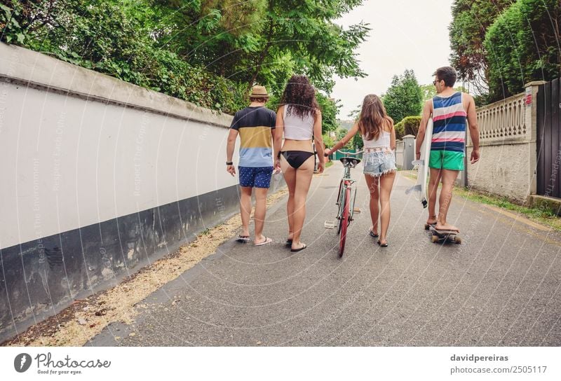 Back view of young people walking along road Lifestyle Joy Happy Leisure and hobbies Vacation & Travel Summer Sports Woman Adults Man Friendship