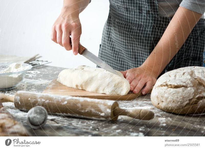 Woman cutting bread dough on wooden table Bread Dough Make kneading Hand Kitchen Apron Flour Yeast Home-made Baking Human being Preparation Stir Ingredients