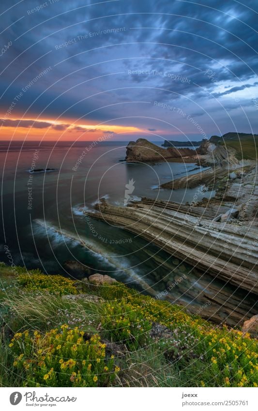 Rocky cliff with sunset on the horizon steep coast steep slope Dusk Deep depth of field Nature Wide angle Brown Blue Colour photo Water Day Exterior shot