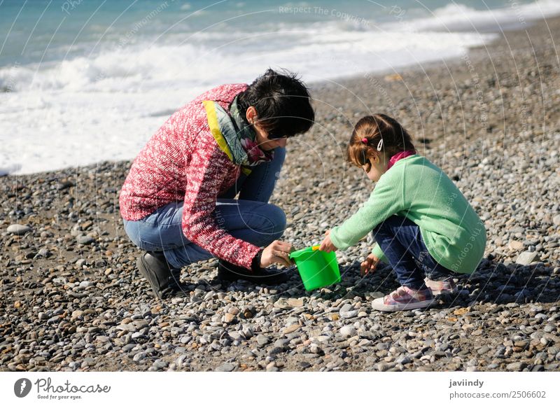 Mother and little daughter having fun on the beach in winter Vacation & Travel Beach Winter Child Human being Girl Young woman Youth (Young adults) Woman Adults