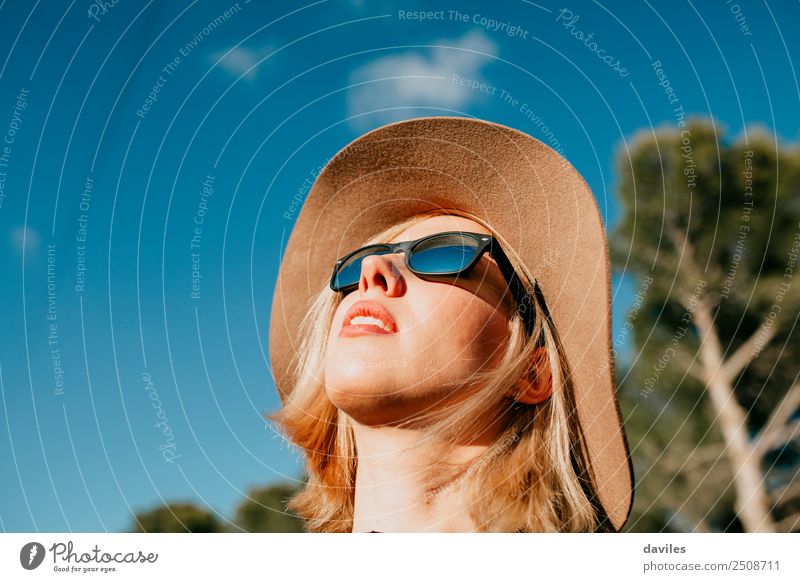 Cute blonde girl having a sunbath in nature with sunglasses and a hat Lifestyle Elegant Style Joy Beautiful Face Wellness Relaxation Vacation & Travel Freedom