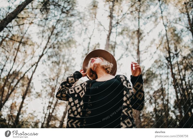 Low angle view of blonde white girl posing in the forest with trees in the background. Lifestyle Elegant Style Beautiful Well-being Vacation & Travel Freedom