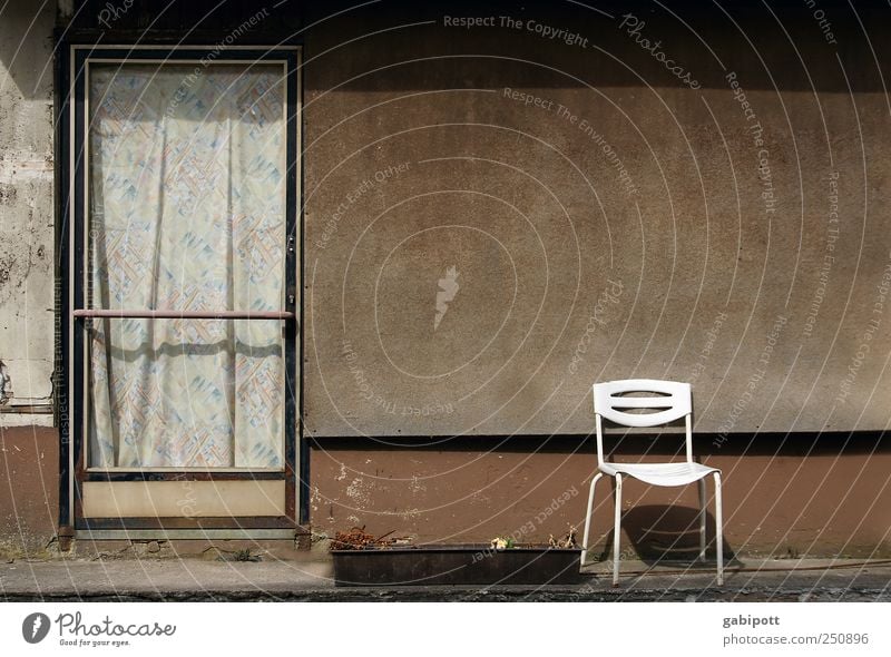 In front of the door Small Town House (Residential Structure) Building Architecture Facade Door Chair Garden chair Curtain Stone Old Authentic Gloomy Brown