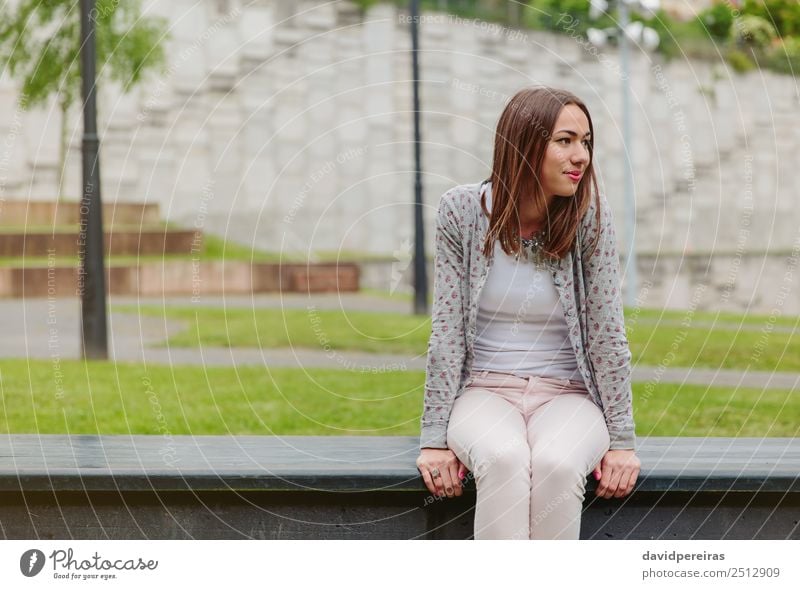 Beautiful young woman sitting on park bench Lifestyle Style Happy Leisure and hobbies Human being Woman Adults Nature Autumn Grass Park Fashion Clothing Jeans