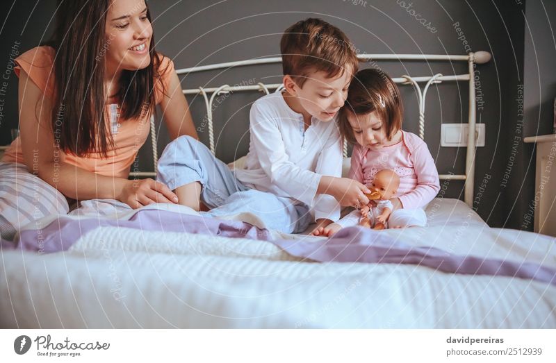 Children feeding doll with cookie sitting over the bed Eating Breakfast Lifestyle Joy Happy Beautiful Relaxation Leisure and hobbies Bedroom Baby Boy (child)